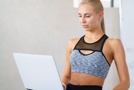 Fitness girl with laptop spends lessons online