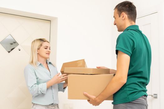 Smiling delivery man giving boxes to woman customer at home for online shopping service concept