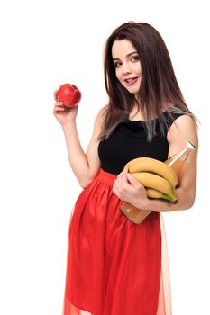Beautiful young smiling woman holding an apple in her hands on a white background isolation. Bright brunette in black and red dress on a white background