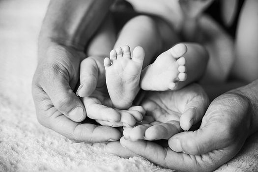 Children's feet in black white. The family