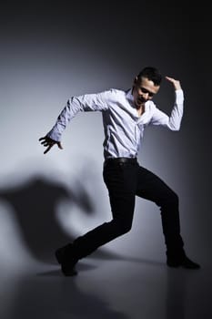 Modern style dancer posing on grey studio background