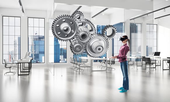 Young woman wearing virtual mask and working with metal gear mechanism. Mixed media