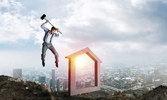 Jumping businessman crashing big house symbol with city view and sunlight on background. 3D rendering.