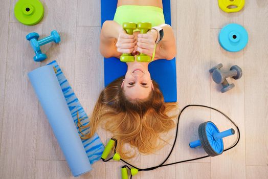 Girl blonde with fitness accessories, top view.