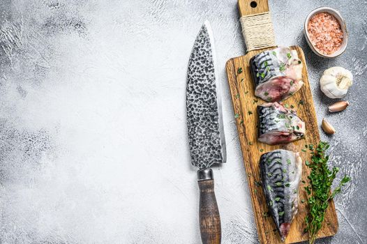 Sliced salted mackerel fish on a wooden cutting board. White background. Top view. Copy space.