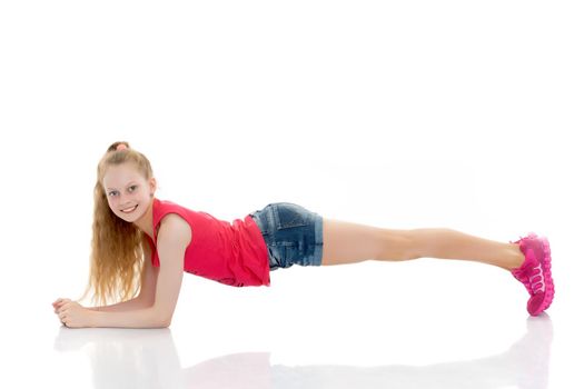 A girl gymnast performs an acrobatic element on the floor. The concept of childhood, sport, healthy lifestyle. Isolated on white background.