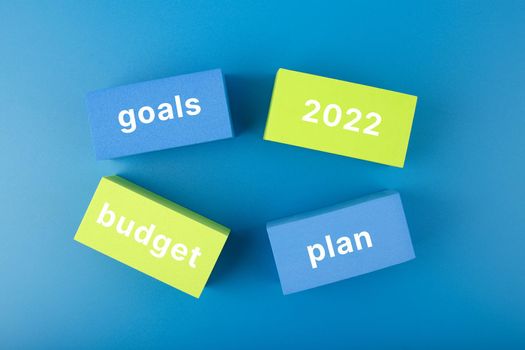 Business plan concept 2022. Budget, plan, goals 2022 written on colored rectangles on dark blue background. Financial goals for 2022