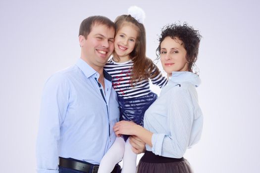 Happy young family, mom dad and little daughter.Parents keep the girl in her arms , and she hugs their neck.