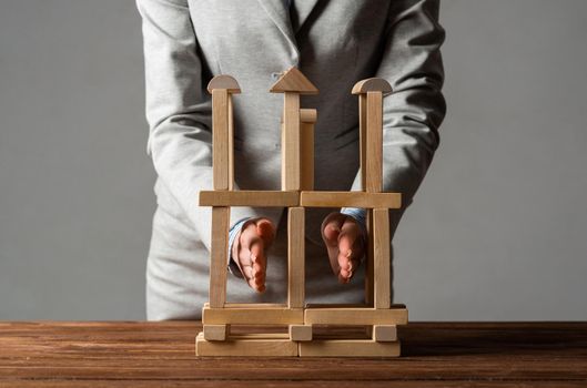 Business woman building construction on table from wooden blocks. Architecture engineering and construction. Company strategy planning, organization and development. Business motivation concept
