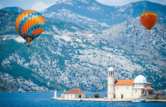 Colorful hot air balloons flying over the lake surrounded by mountains. large multi-colored balloons slowly rising against blue sky. Travel, adventure, festival