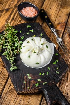 Cheese Burrata mozzarella on a wooden cutting board. wooden background. Top view.