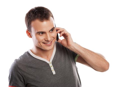 Young and healthy man answering the phone against a white background
