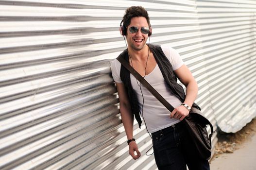 Portrait of young happy man smiling in urban background