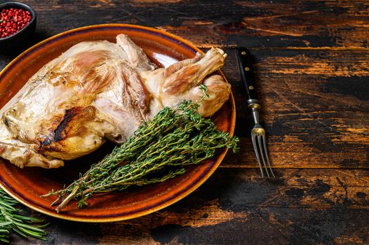 Roasted whole lamb shoulder. Dark wooden background. Top view. Copy space.