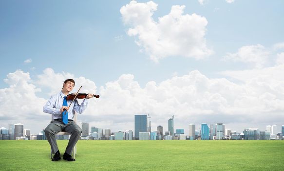 young businessman is engaged in music, meditation and a serene field around