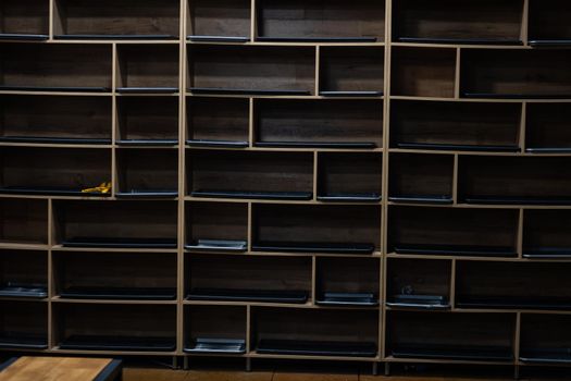 wooden shelf at black wall background.