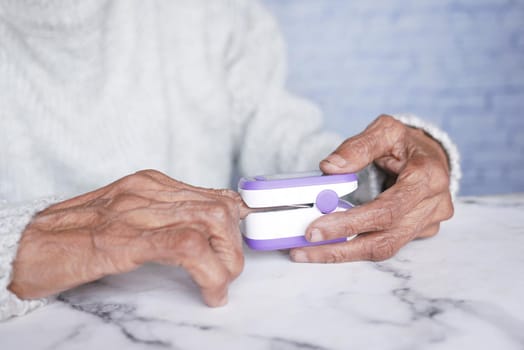 senior young women hand using pulse oximeter.
