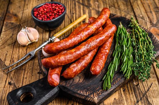 Pork Smoked sausages with addition of fresh aromatic herbs and spices. wooden background. Top view.