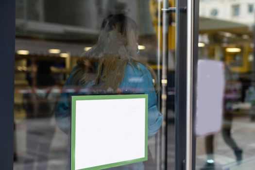 The front door of a office block, reflecting buildings in the glass.