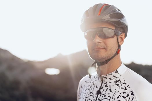 Portrait of male caucasian cyclist with helmet and glasses close up