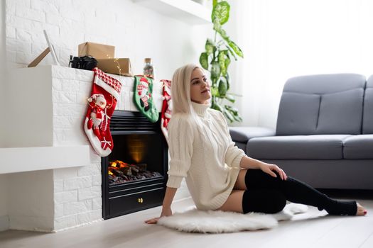 Happy young lady by the fireplace. Christmas New year concept.