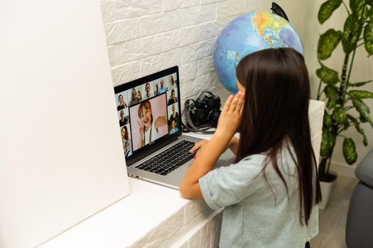 Litttle girl looking at laptop screen with expression of surprised and excitement. Smart, smilling little girl taking notes . Communication in business concept.