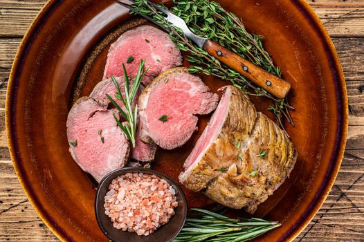 Grilled Roast beef fillet meat on a rustic plate with salt. background. Top view.