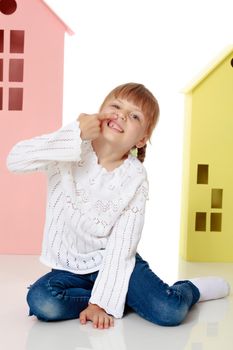 A good girl shows her finger so that she does not have a tooth. The concept of oral care. Isolated on white background.