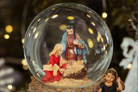 Scene of the nativity of Jesus Christ in a glass ball on a Christmas tree