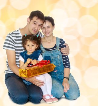 Happy young family with little daughter cuddling together in celebration of Christmas.Brown festive, Christmas background with white snowflakes, circles.