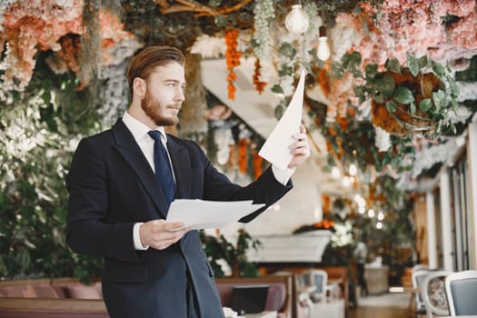 Guy in a black suit. Male at the restaurant.