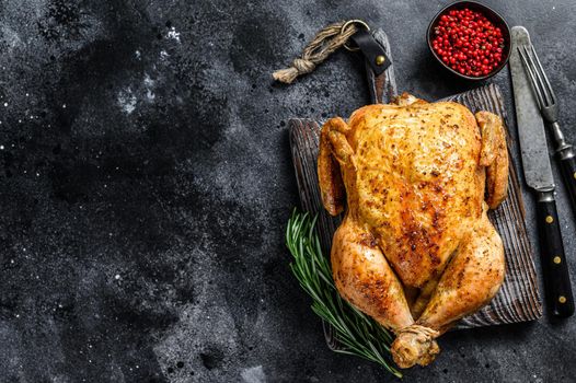 Grilled roasted whole Chicken. Black background. Top view. Copy space.