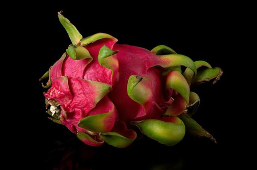 Dragon fruit horizontally on a black background with reflection