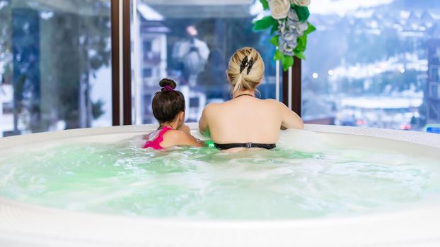 Woman with her daughter foot in hot tub jacuzzi