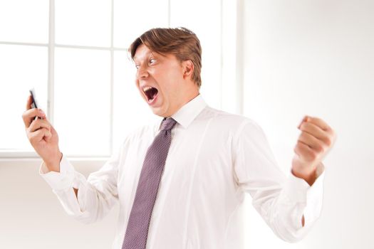 Close up of a successful and laughing businessman on the phone in his office