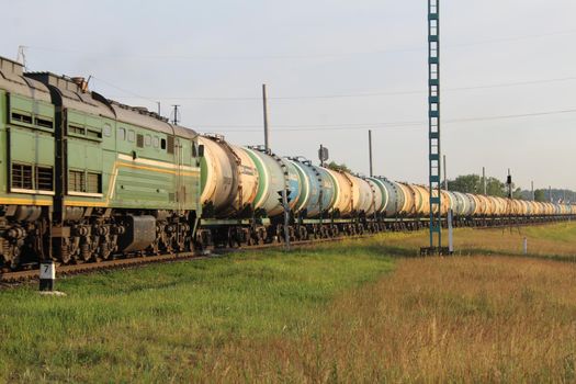 eating cargo rides among the grass meadows against the sky. Rail transport. Transport.