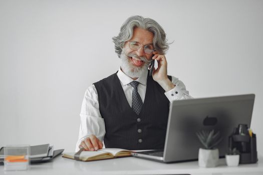 Elegant man in office. Businessman in white shirt. Man works with phone.