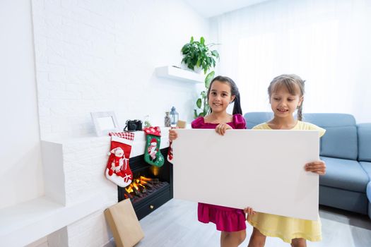 two little girls standing with empty horizontal banner in hands, a photo canvas