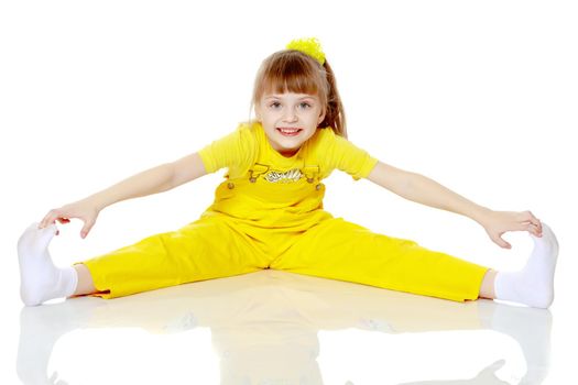 Girl with a short bangs on her head and bright yellow overalls.She crouched down on the white advertising banner.