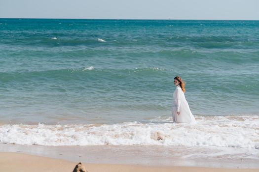 Woman in white dress freedom walk on ocean island. High quality photo