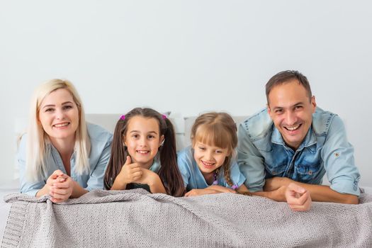 Happy family lying on a bed together in the bedroom