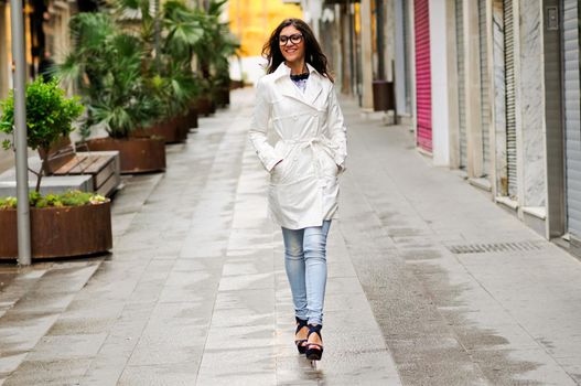 Portrait of a beautiful woman with eyesglasses walking in urban background