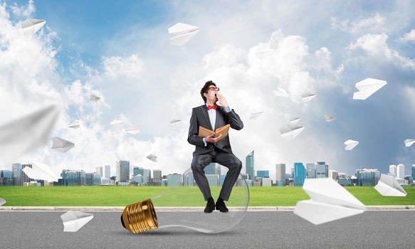 young businessman with a book. flying around paper plane in chaos