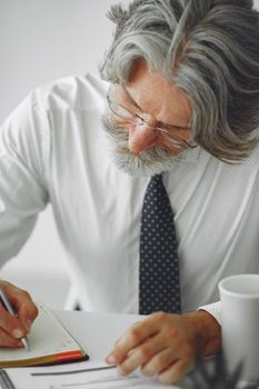 Elegant man in office. Businessman in white shirt. Man works with documents.