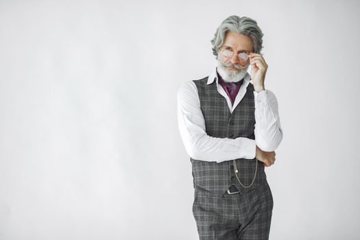 Close up portrait of grinning old-fashioned man. Elegant man in a studio. Grandfather with a clock.