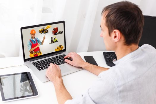 Portrait of happy repairman on laptop screen