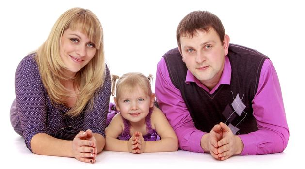 Happy family of three mom, dad and adorable little daughter lie on the floor and looking at camera-Isolated on white background