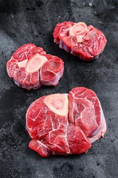 Fresh veal meat osso buco shank steak, italian ossobuco. Black background. Top view.