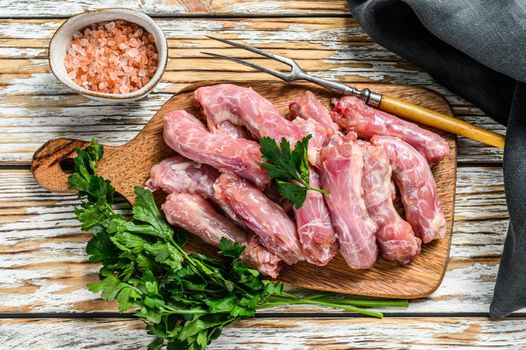 Raw Chicken neck meat, offals. White Wooden background. Top view.