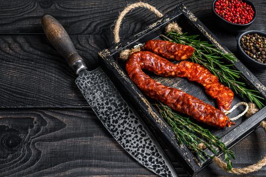 Sliced chorizo salami, Spanish traditional chorizo sausage. Black wooden background. Top view. Copy space.